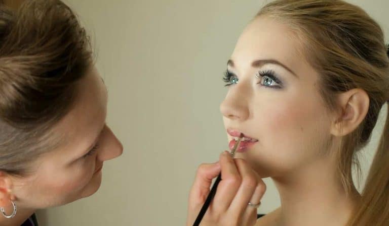 makeup artist putting makeup on girl