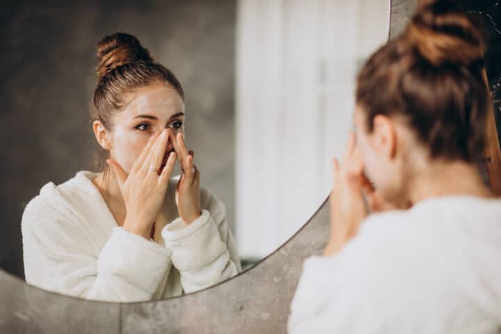 woman in mirror with pilling makeup